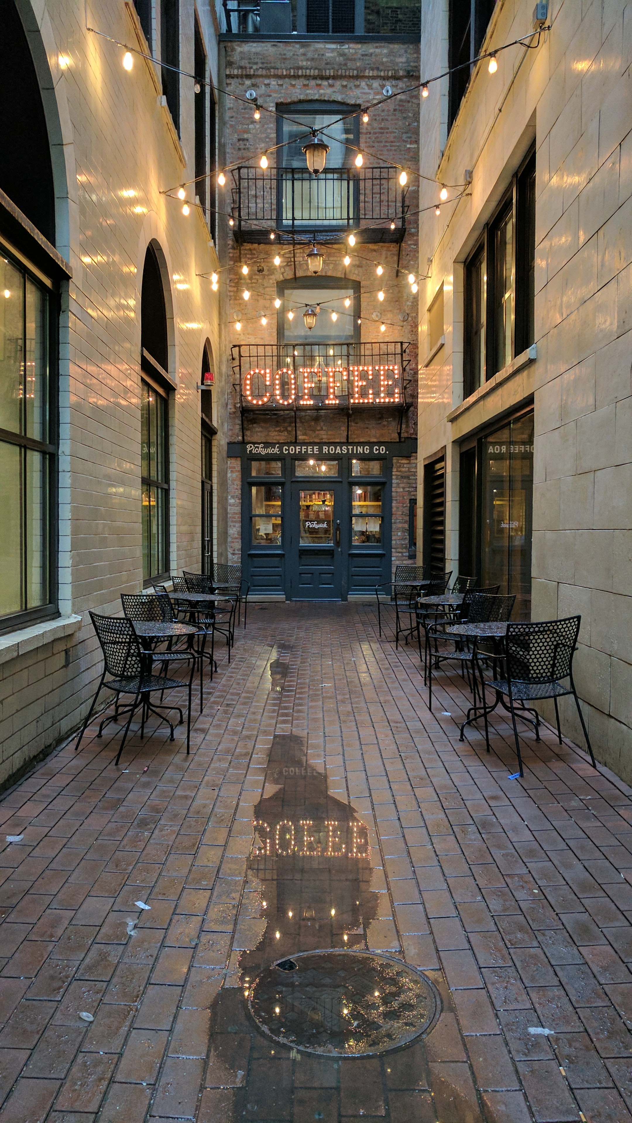 Exterior of blue cafe in alleyway with chairs