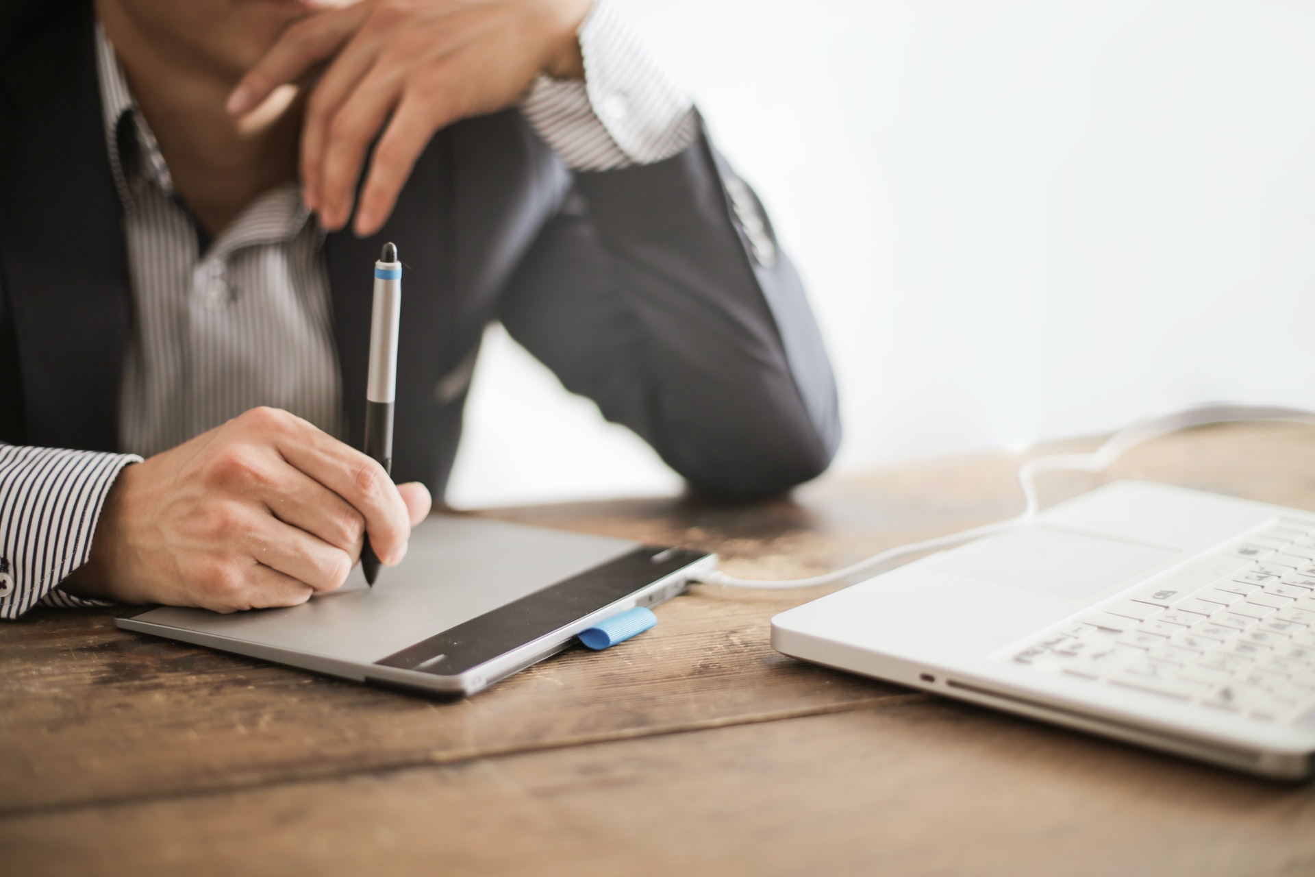 man using drawing tablet on laptop