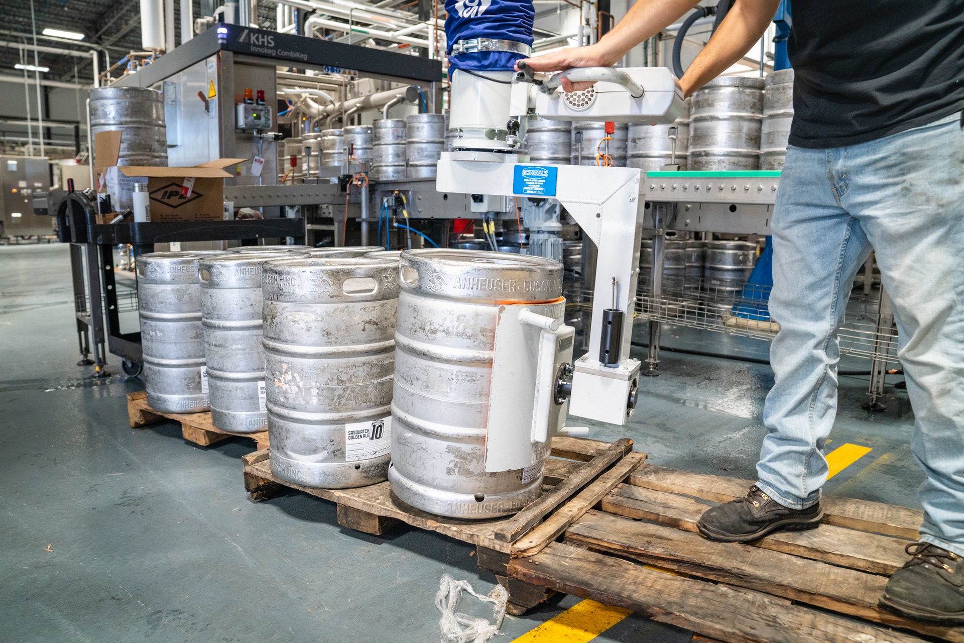 Man on palette with kegs in warehouse