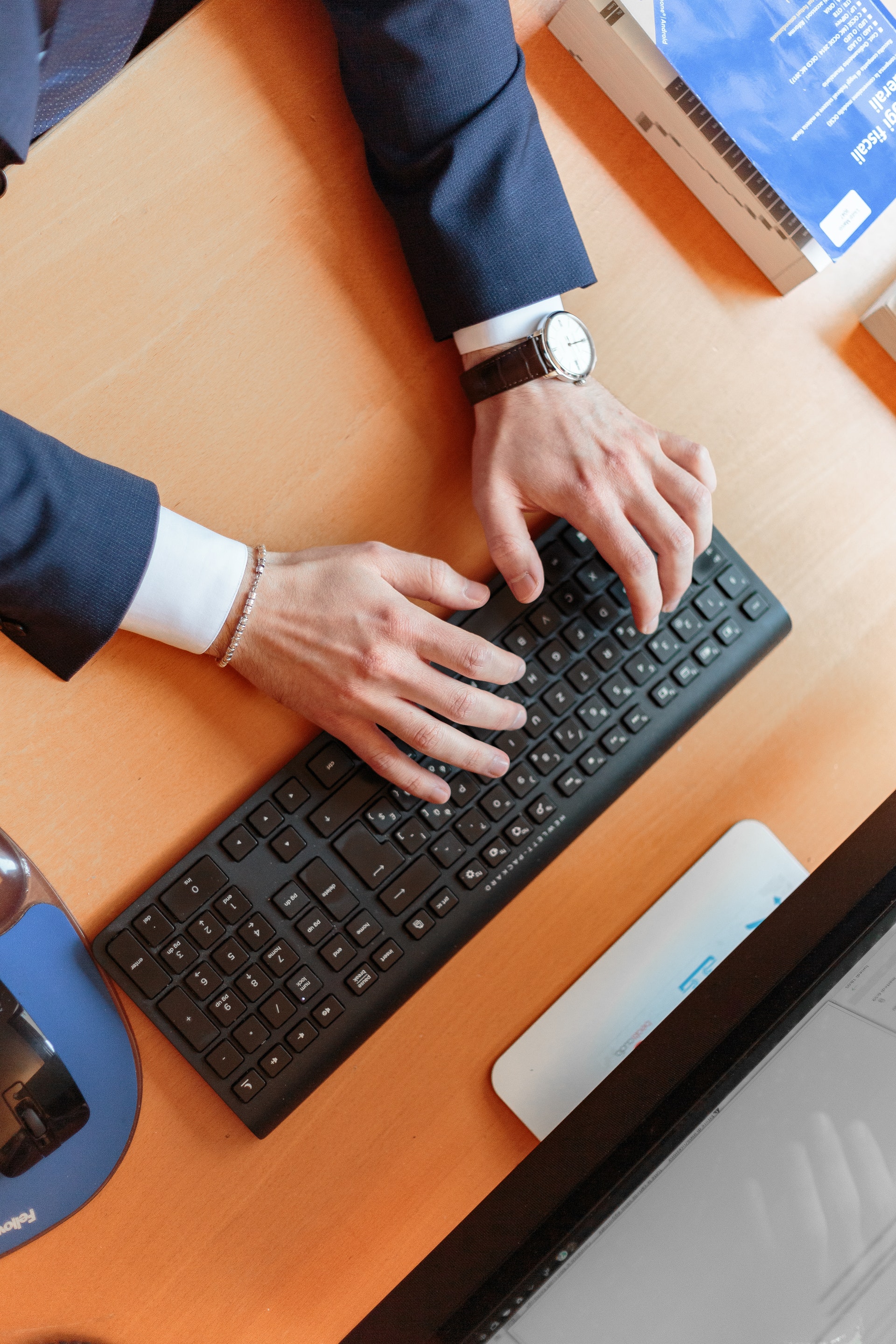man in suit typing on laptop