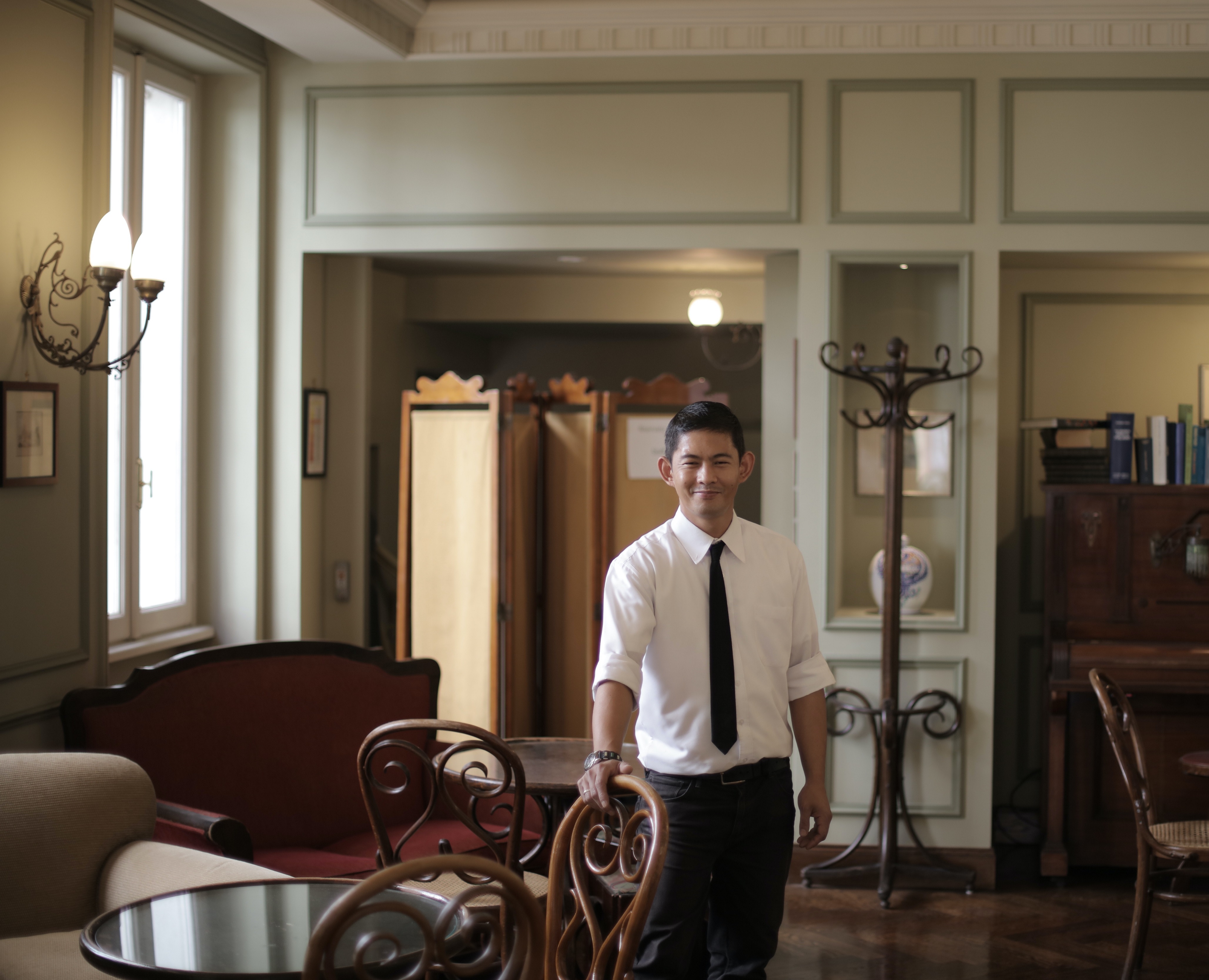 man in tie standing in antique looking room