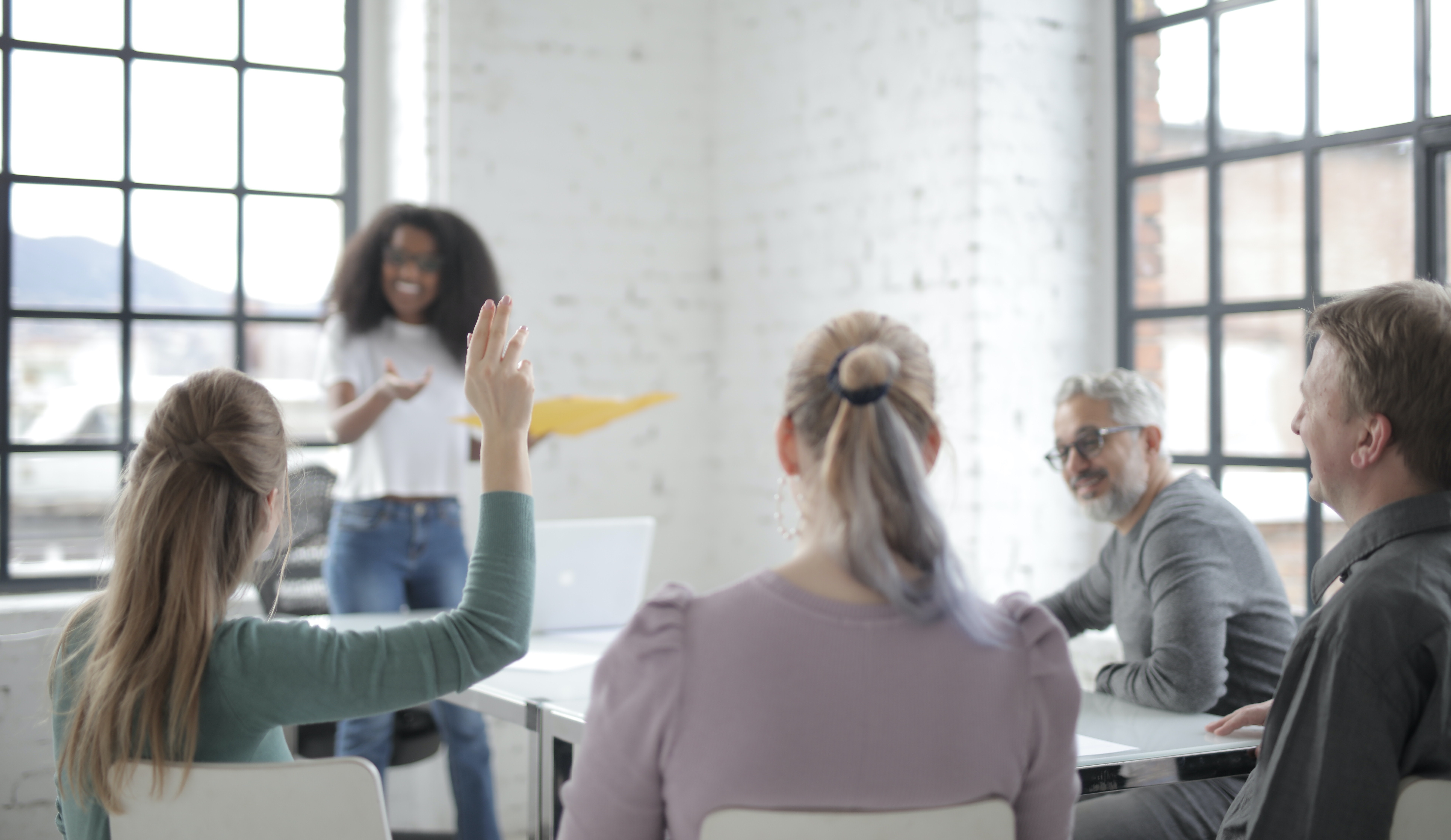 woman raising hand in group work setting