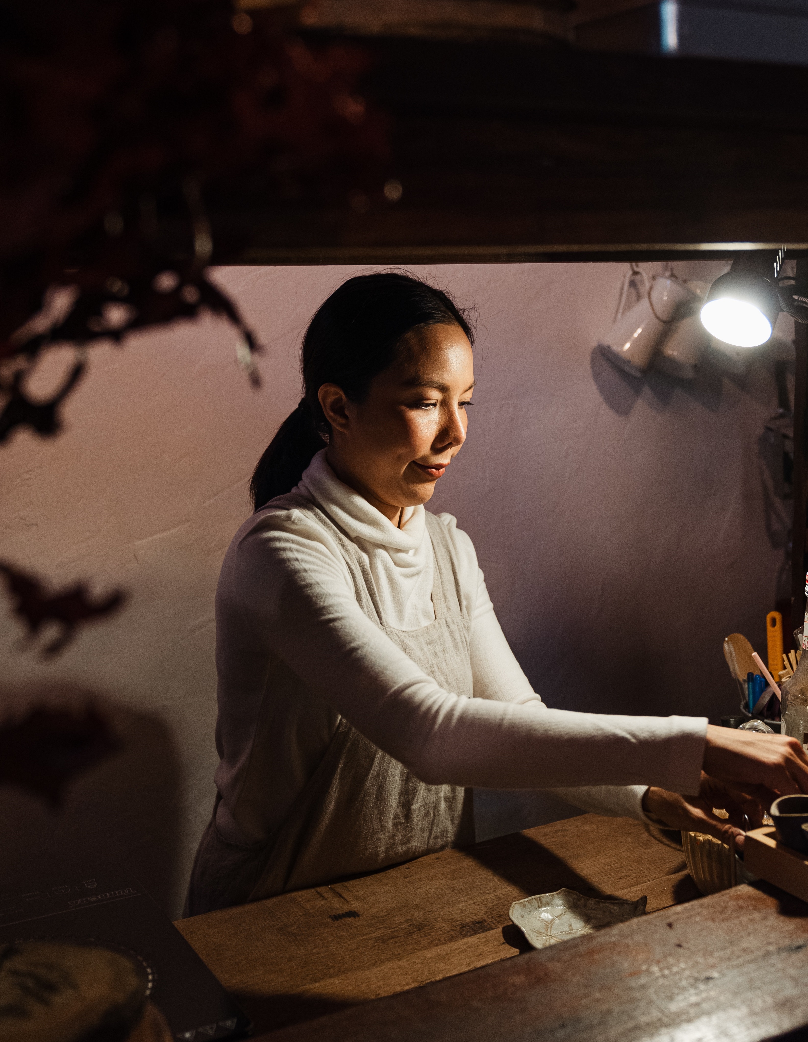 woman standing next to woodworking table working