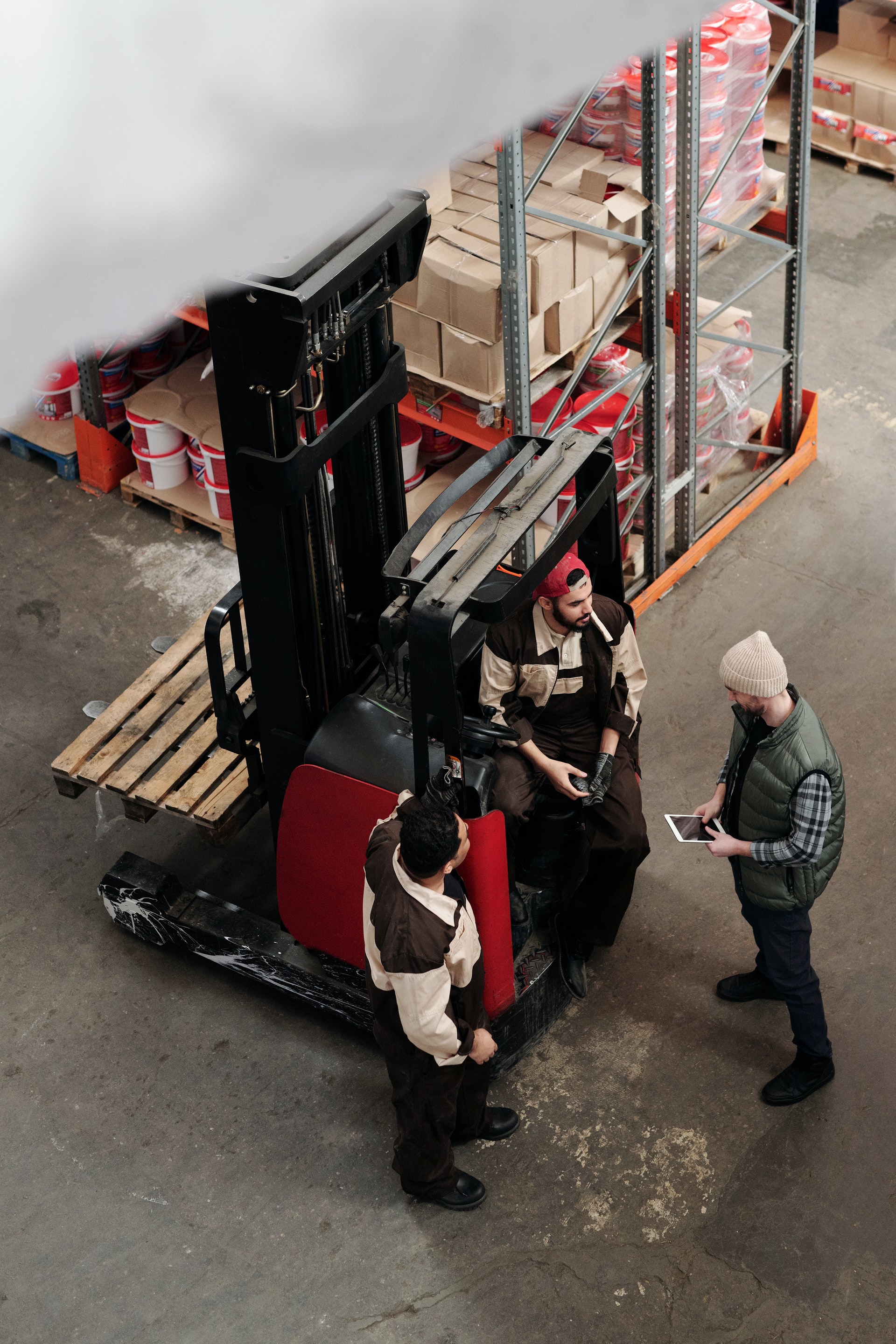 three men talking around forklift in warehouse