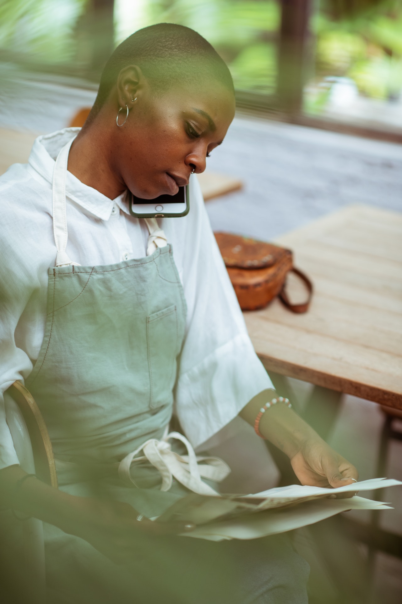 waitress-on-phone-sitting-down-sorting-papers